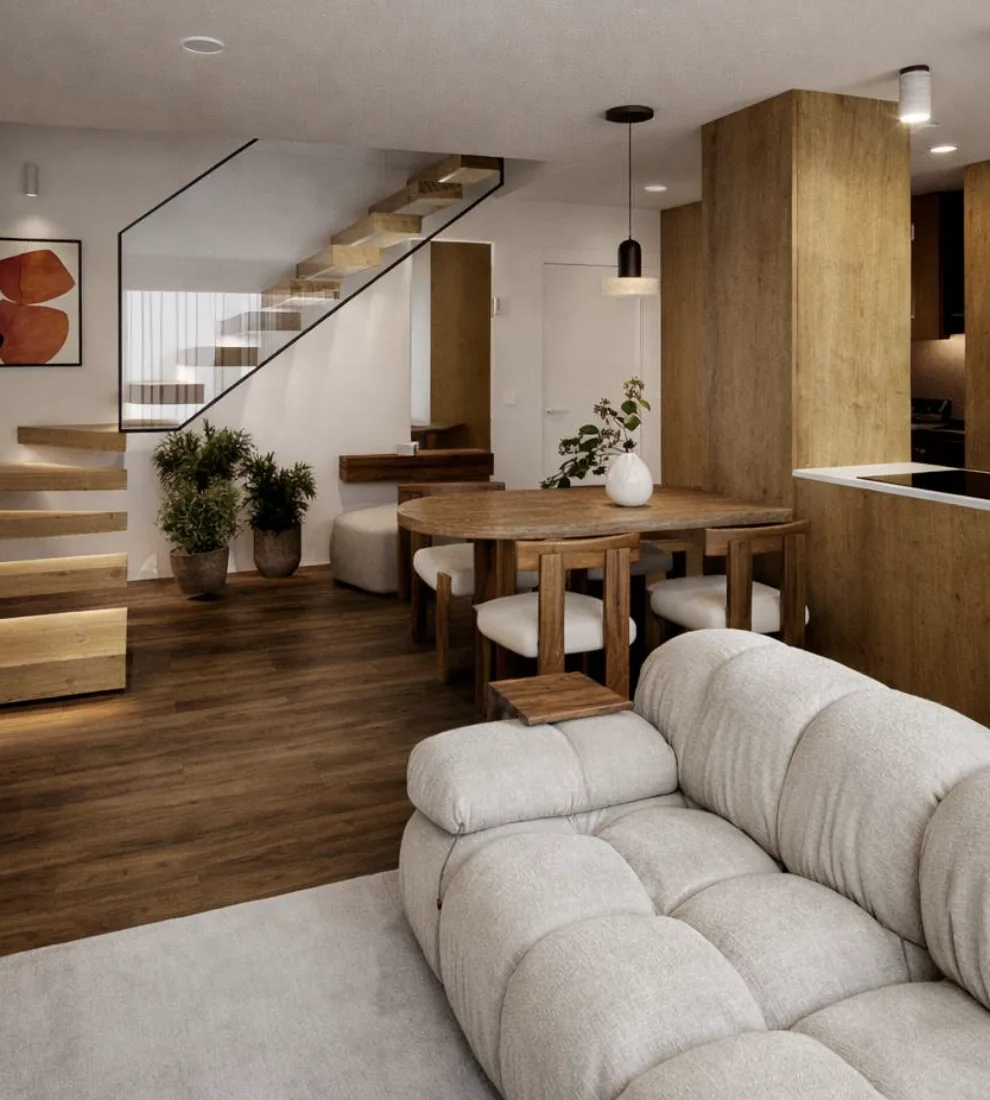 Sala com sofá claro, mesa de jantar e escadas em madeira, integrada com a cozinha