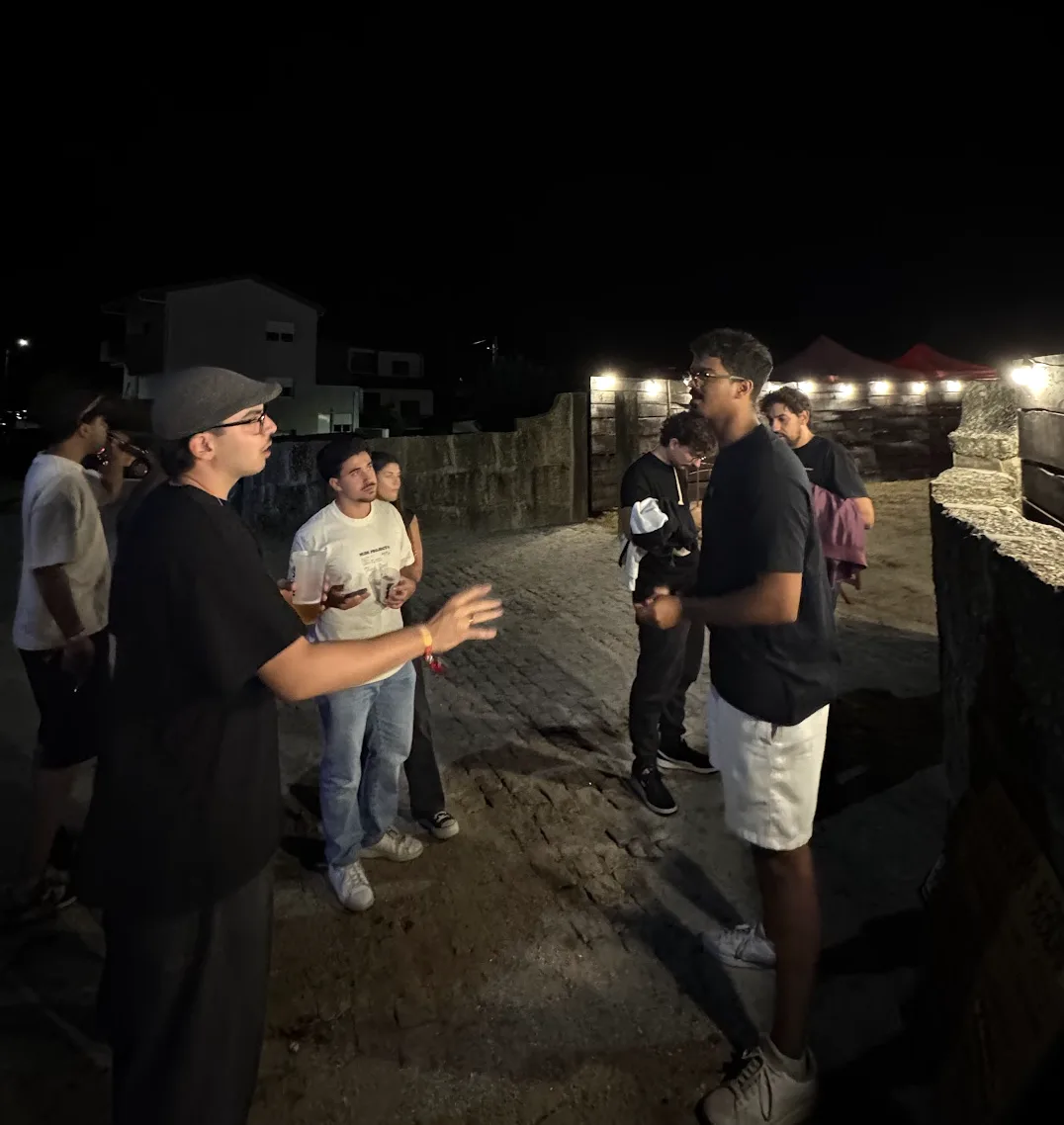 Leo à conversa com um grupo de jovens junto à entrada do festival, à noite