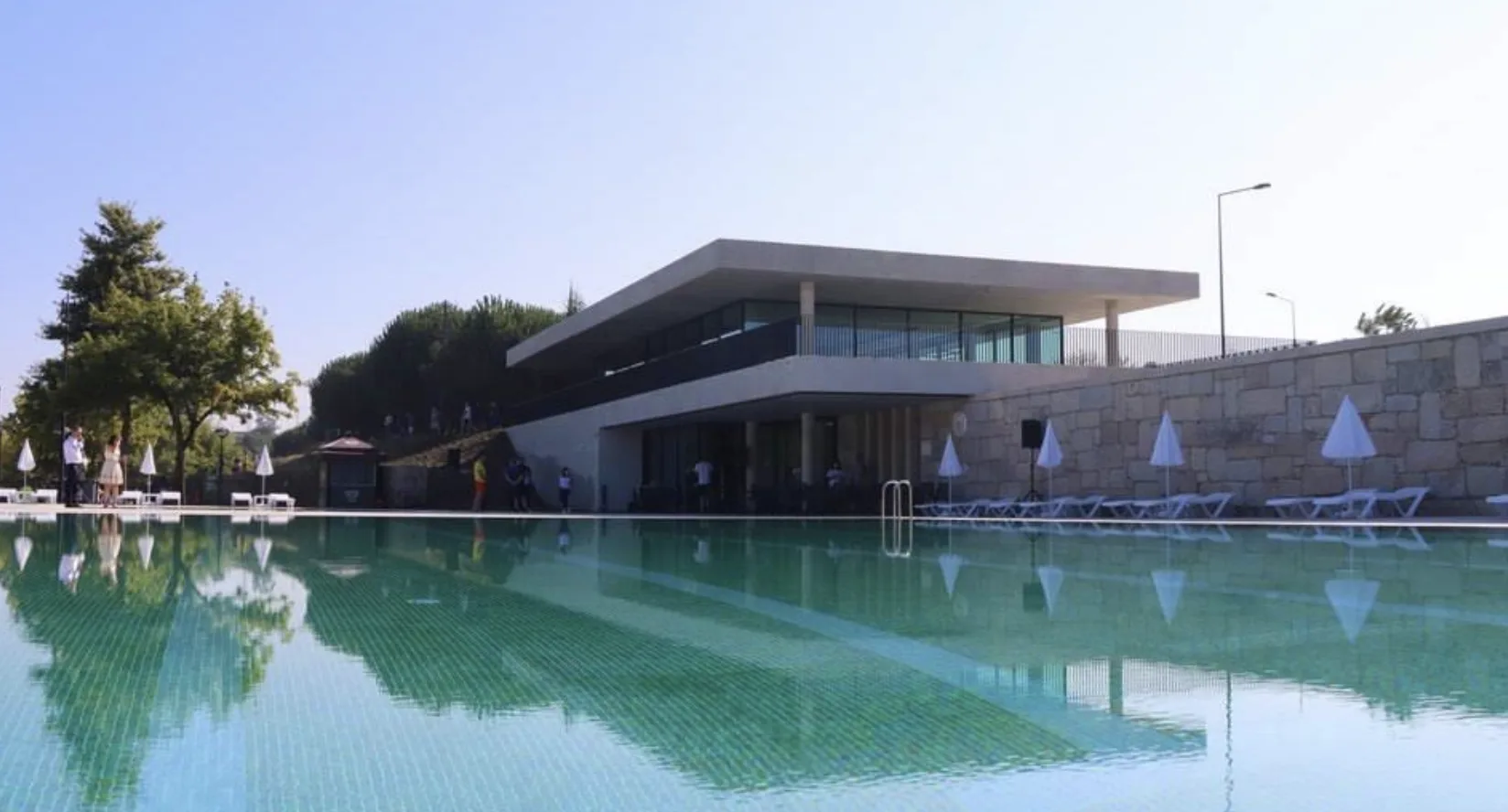 Piscina Verde, em Paredes, com o edifício e as espreguiçadeiras refletidos na água