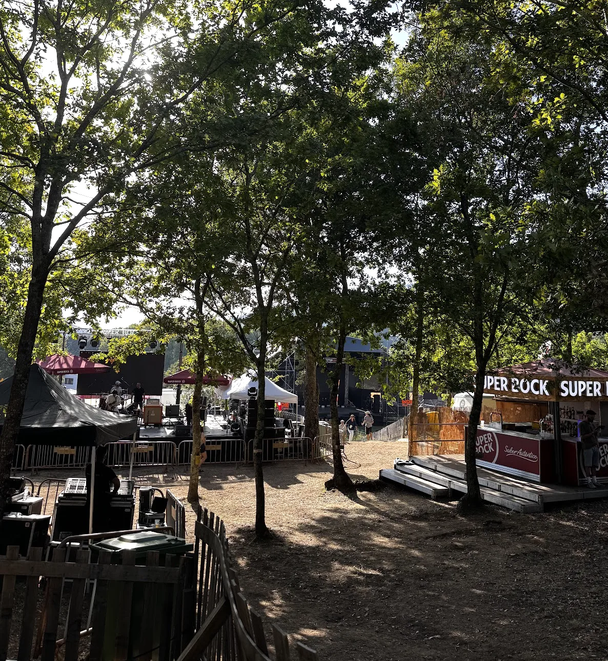 Recinto do Indie Music Fest de dia, com palcos e barracas entre as árvores da Floresta Mágica