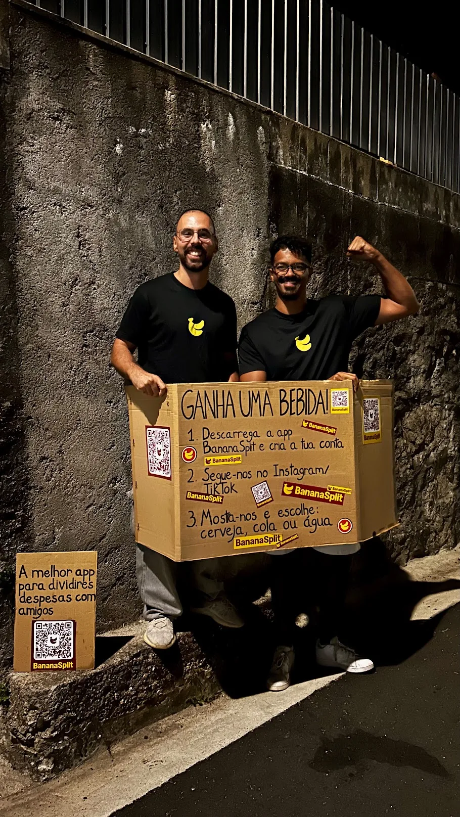 Two BananaSplit team members with the campaign sign at night
