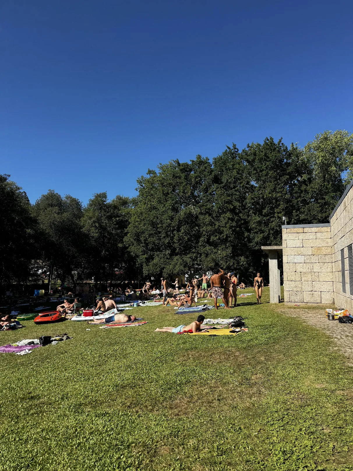 Groups on the grass by the Paredes de Coura river