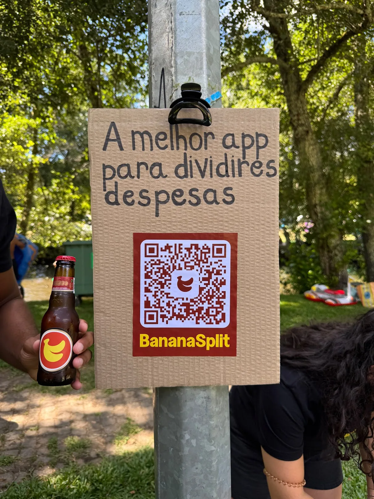 Cardboard BananaSplit sign with a QR code by the river