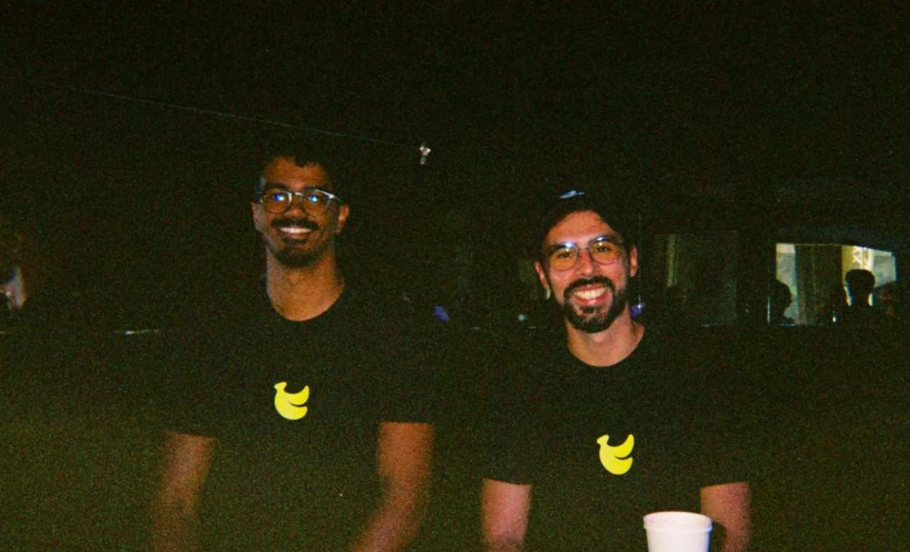 BananaSplit founders Leonardo on the left and Diogo on the right, smiling together in black BananaSplit T-shirts at night