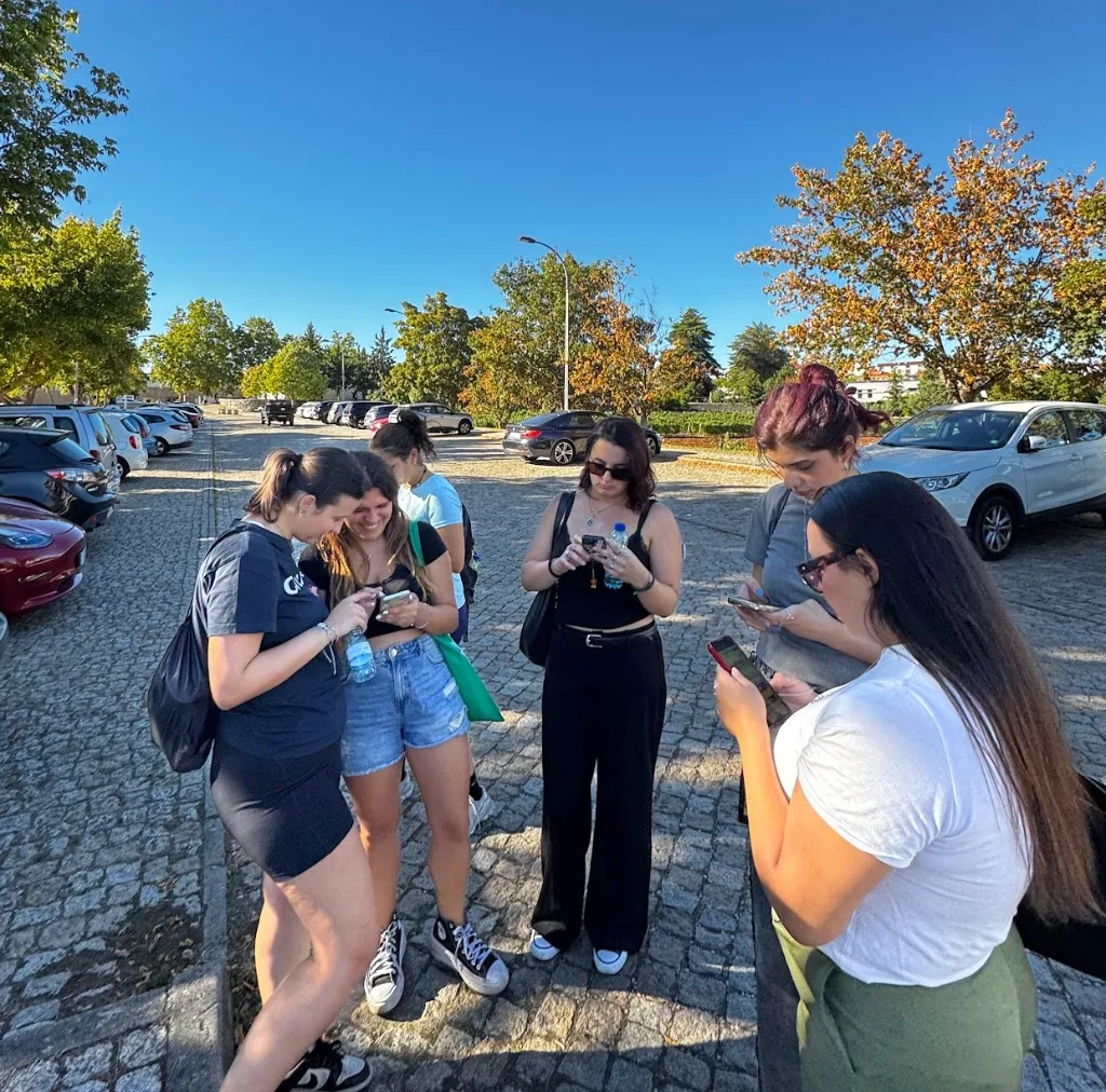 Estudantes Erasmus reunidos em volta dos celulares na campanha do BananaSplit na UPB